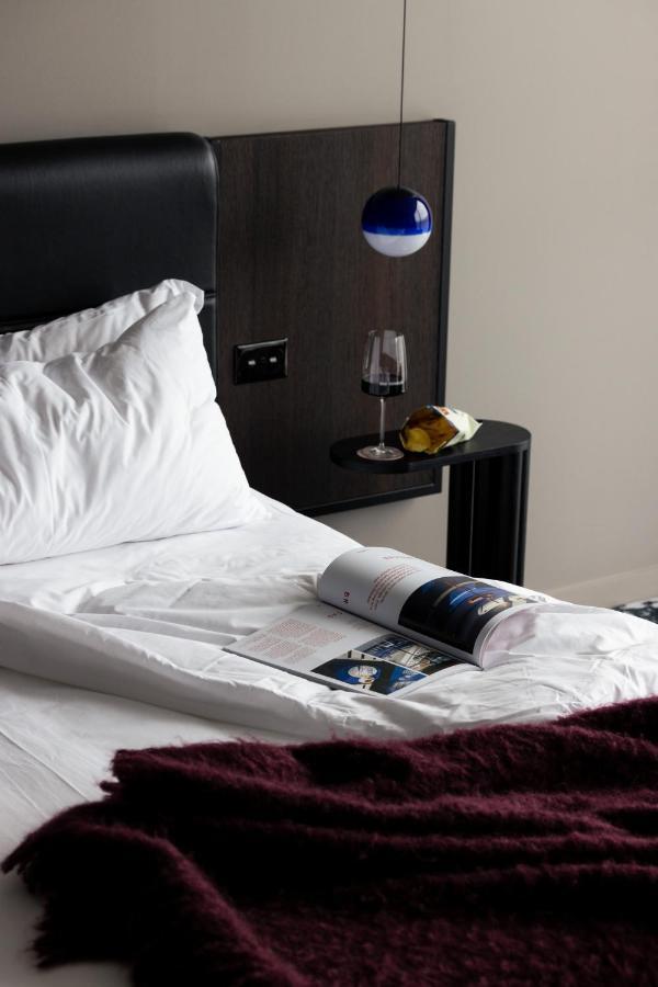 Ebb-Dunedin Exterior foto A bed with a magazine and a wine bottle